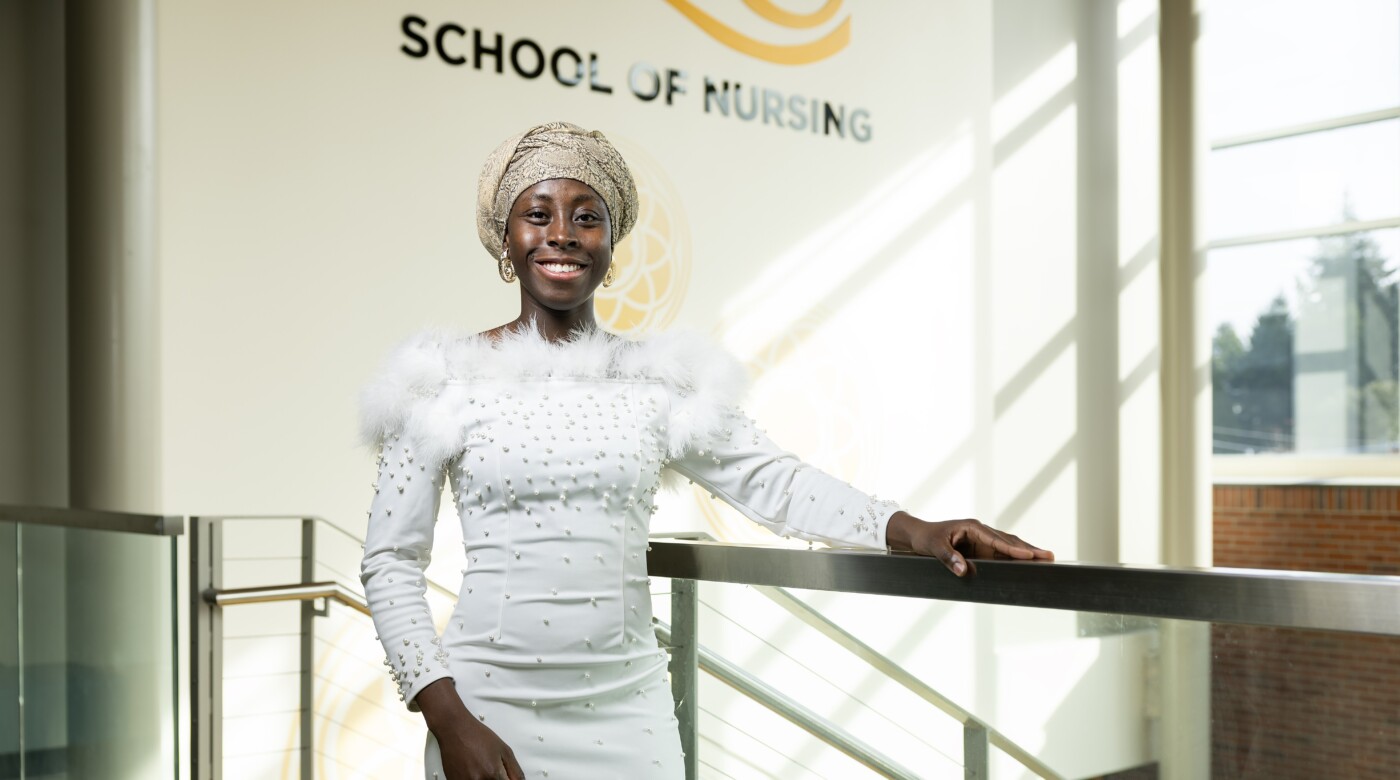 Woman in white beaded dress in School of Nursing building at PLU.