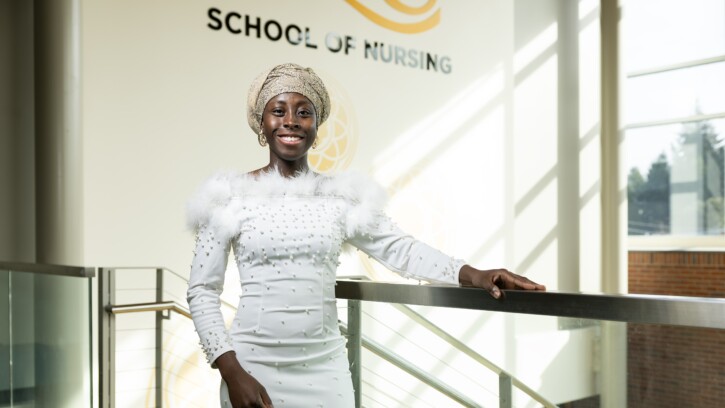 Woman in white beaded dress in School of Nursing building at PLU.