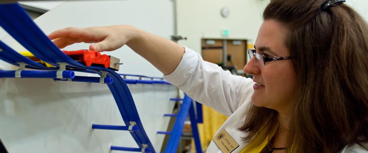 Katie Hay running a toy car on a track in a physics demo.