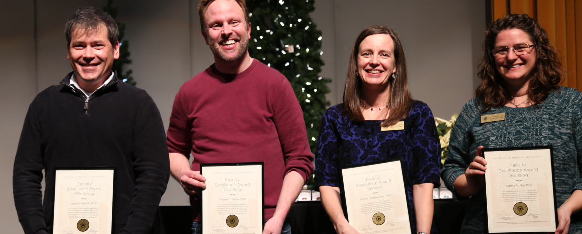 Four faculty members holding their awards