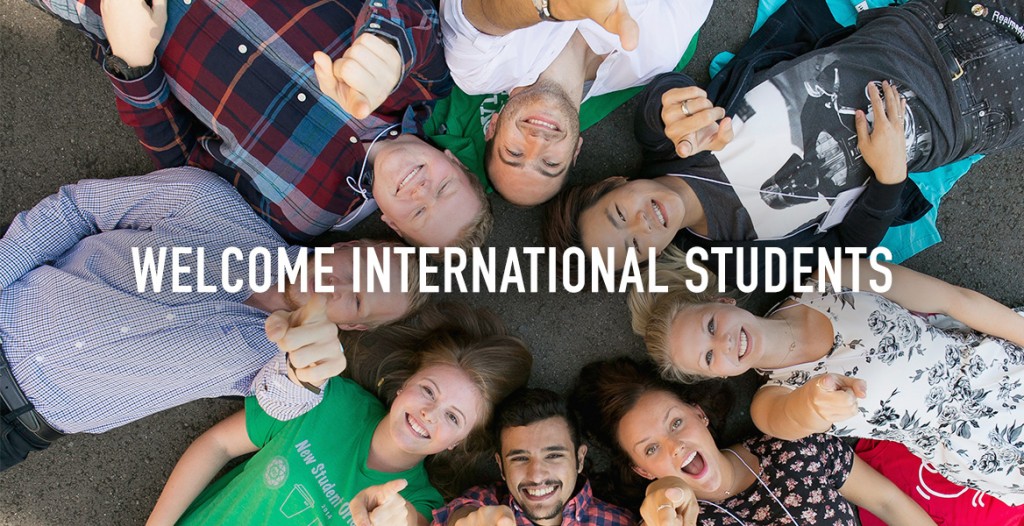 Welcome International Students - students on ground in circle looking up at camera