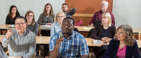 Three rows of engaged adult students at tables