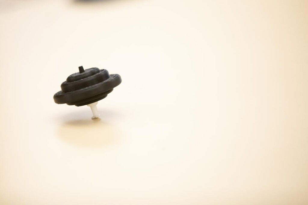 20221209_SB_ENGR-131_012-medium Black spinning top on light background.