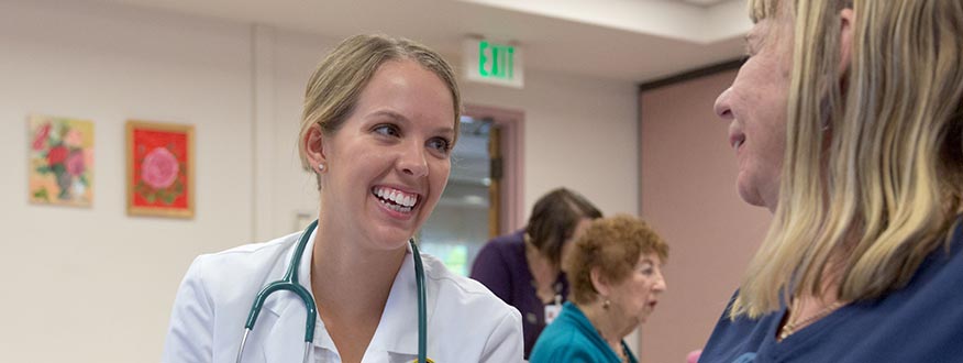 Doctor of Nursing Practice Pacific Lutheran University banner - Nursing student smiling at patient