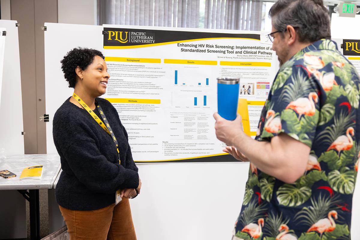 Woman presenting HIV research poster to male visitor at conference