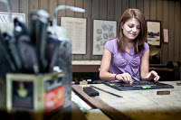 PLU student and Elliot Press assistant, Caitlin Harris, prints at job for Campus Ministry at the Elliot Press Studios in Parkland.