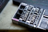PLU student and Elliot Press assistant, Caitlin Harris, prints at job for Campus Ministry at the Elliot Press Studios in Parkland.