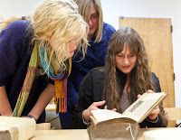 students looking at a really old book