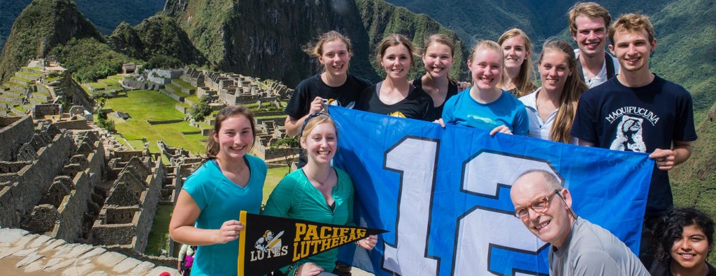 Chuck Bergman and class showing their Seahawk flag in another country