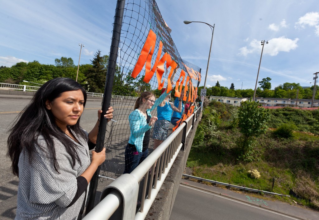 PLU Students holding an banner over Interstate 5 in Tacoma.