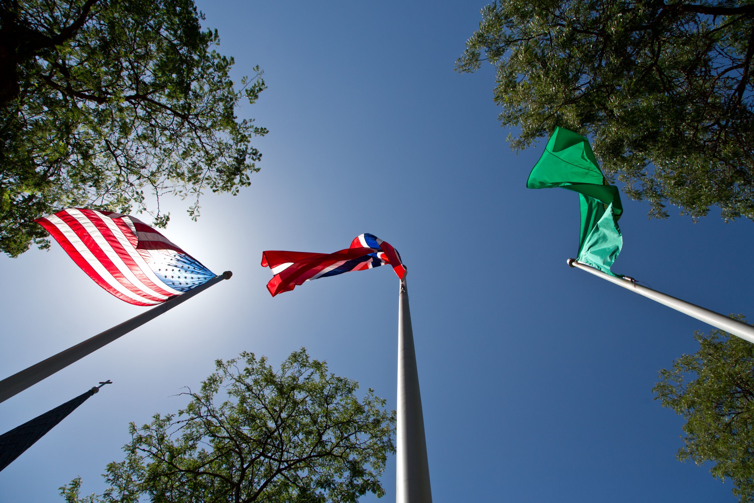 The flags of the United States, Norway and the State of Washington billow in the breeze above Red Square at PLU on Monday, July 20, 2015. (Photo: John Froschauer/PLU)