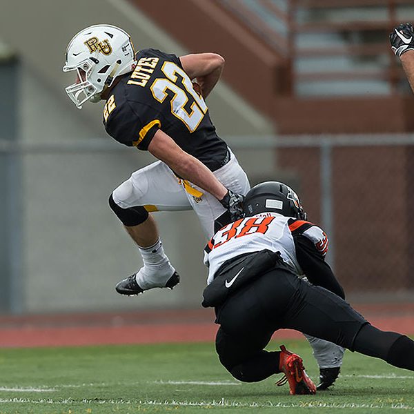 A PLU football player avoids a tackle