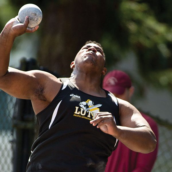 A PLU track and field athlete shot puts the ball