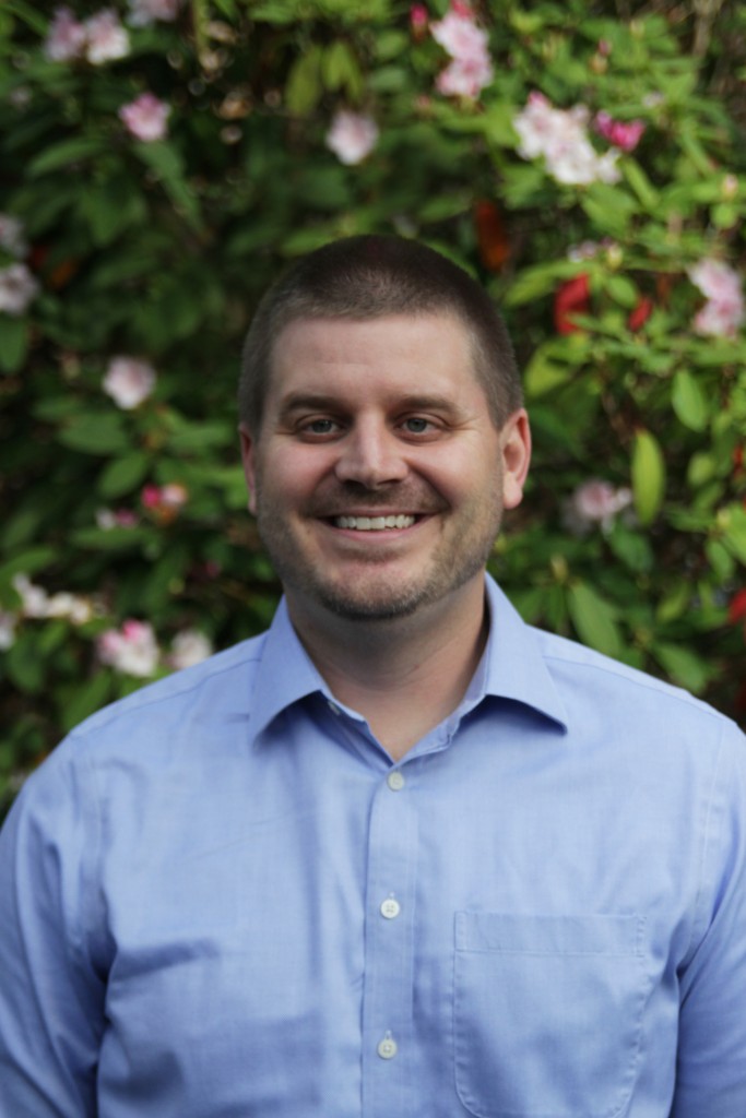 Portrait of Dr. Seth Dowland in front of Rhododendrons