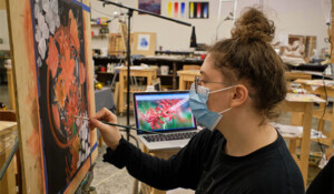 PLU student painting in a studio in Ingram Hall.