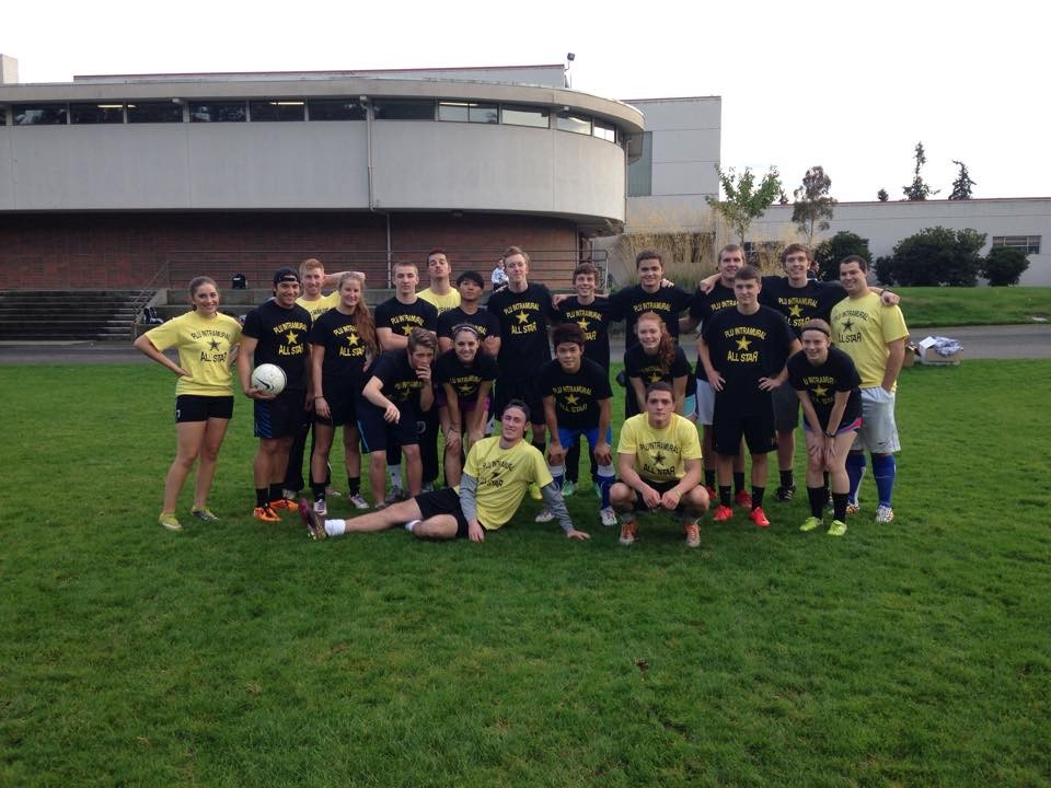 Group photo of students with soccer ball on Foss field