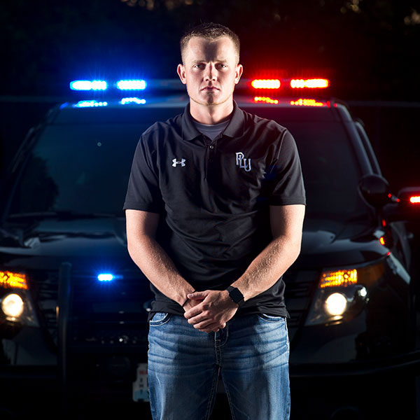 Landon Packard '17, poses with the lights and a Puyallup PD car behind