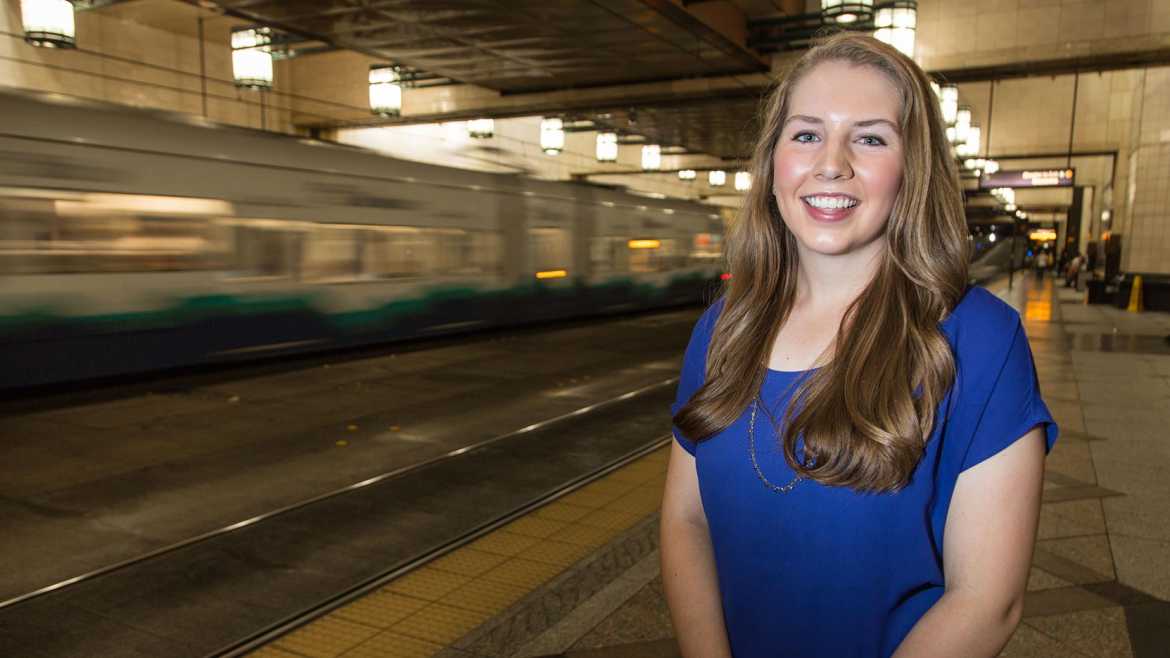 Anna Jessen poses in downtown Seattle tunnel with the Link light rail and busses