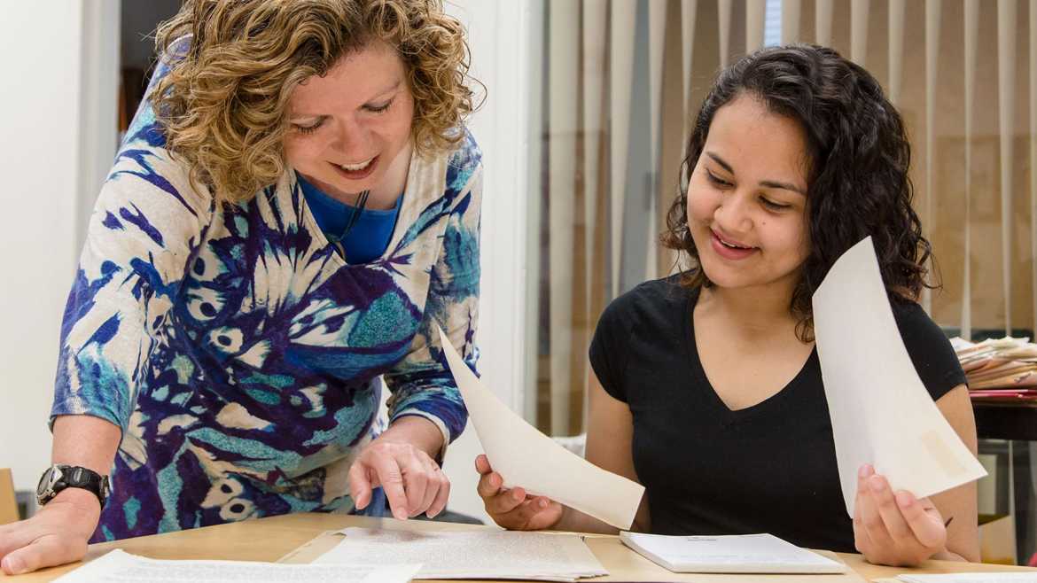 Prof. Gina Hames and Sandra Estrada work in the library at PLU