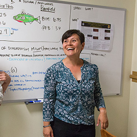 Heidi Schutz smiling in front of a whiteboard