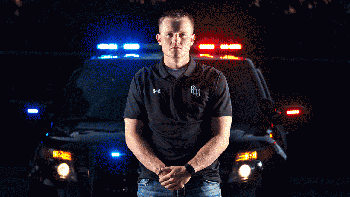 Landon Packard '17, poses with the lights and a Puyallup PD car behind