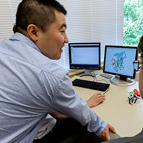 Rhenzi Cao chatting with a student on a compuer