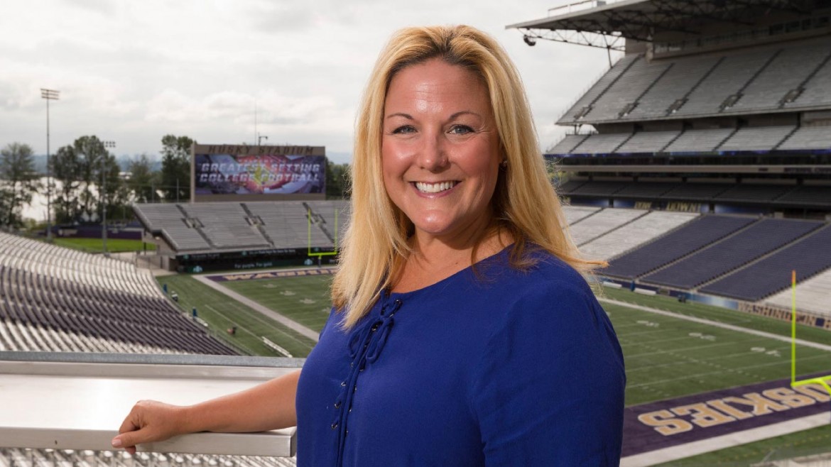 Jen Cohen standing in the stands at the University of Washington football field