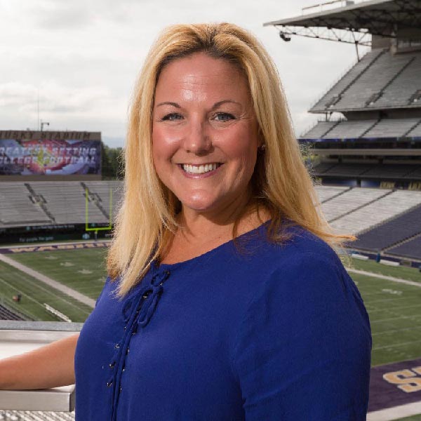 Jen Cohen standing in the stands at the University of Washington football field