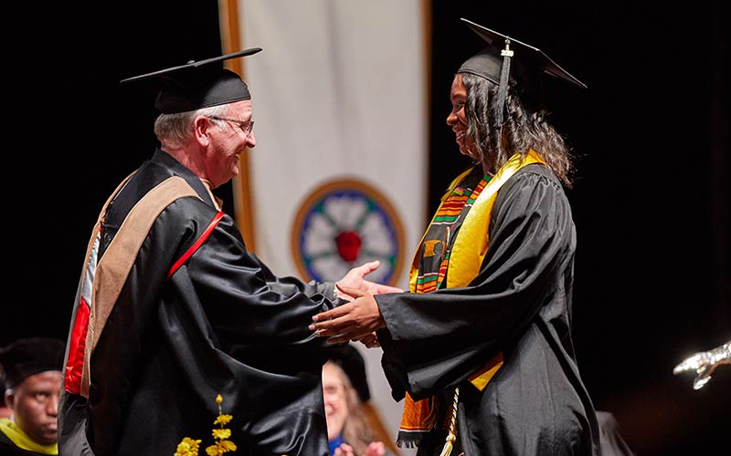 President Allan Belton shaking hands with a recent graduate from Pacific Lutheran University.