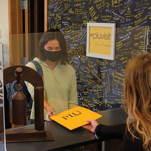 PLU students in the Welcome center wearing protective masks