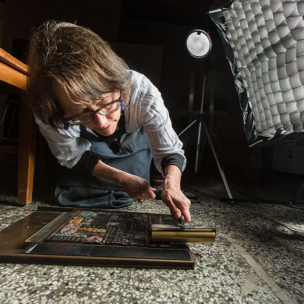 Jessica Spring carefully rolls a layer of metallic gold varnish onto the chase lockup featured on the cover of the spring issue of ResoLute. Spring, with assistance from colleague Mare Blocker, crafted the design out of wood and metal type from the Thorniley Collection, a major donation that has expanded Pacific Lutheran University’s letterpress collection.