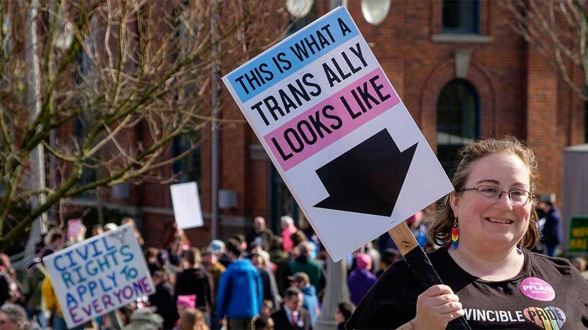 Laura Brewer '03 holding a sign at a trans movement