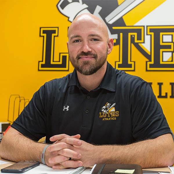 Brant McAdams - new PLU football coach - sitting at his desk