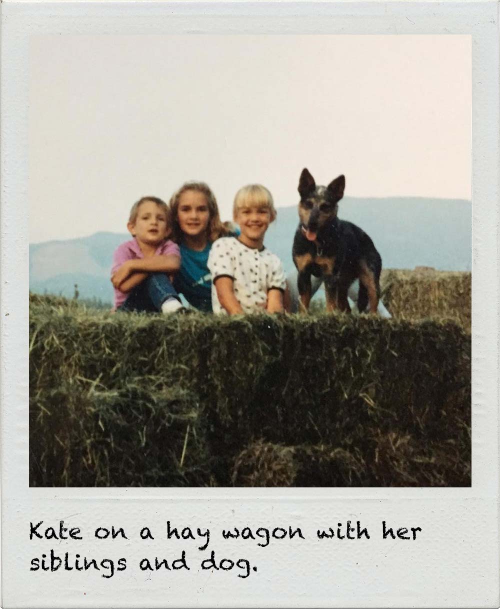 Kate on a hay wagon with her siblings and dog.