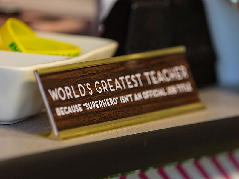 Malia Oshiro has a nameplate on her desk that reads "World's Greatest Teacher because 'superhero' isn't an official job title