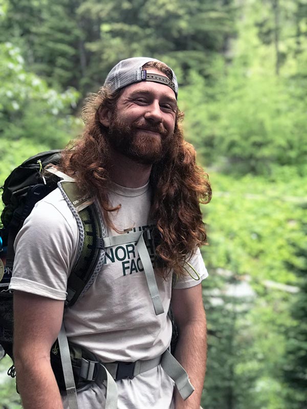 Isaiah Scheel smiling while on a hike