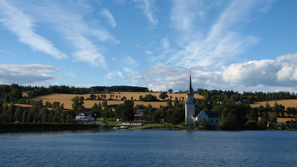 A scenic backdrop of a blue sky and calm lake in Norway