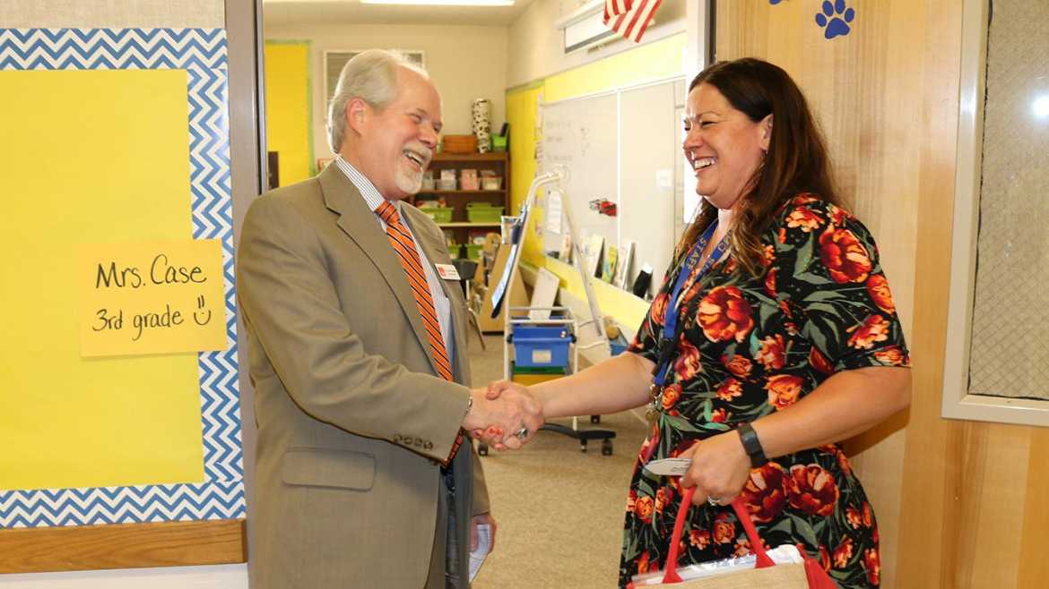 Frank Hewins shaking hands with a teacher