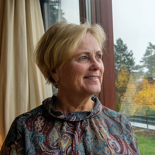 Thorhild Widvey looking out her window in her home