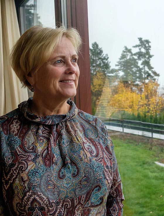 Thorhild Widvey looking out her window in her home