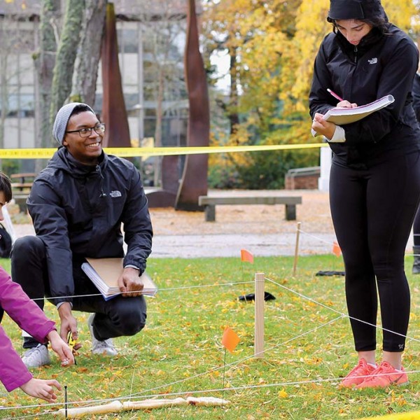 Students in a forensic anthropology class investigate a faux crime scene.