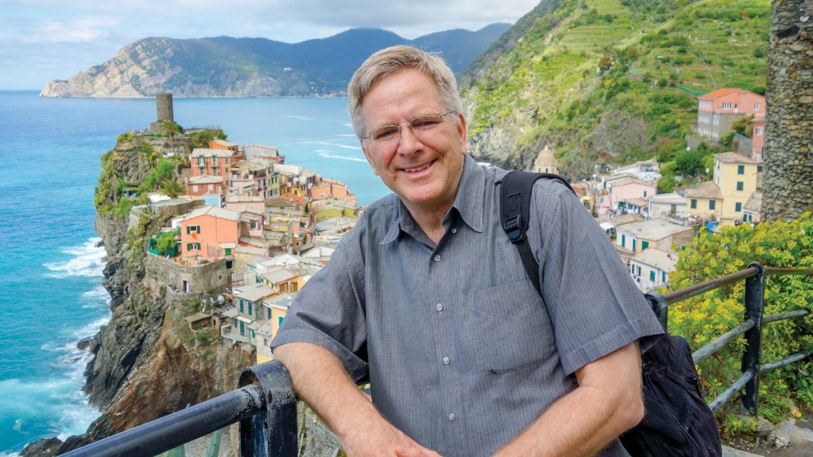 Rick Steves leaning on a fence posing in Cinque Terre, Italy