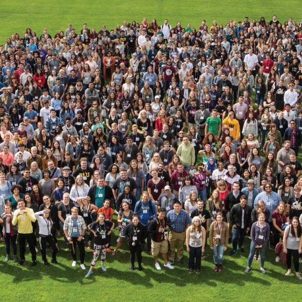 New incoming students gather on Foss Field for a group photo during orientation weekend.