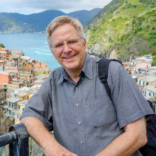Rick Steves leaning on a fence posing in Cinque Terre, Italy