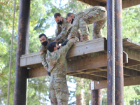 Cadets helping each other up ropes course event