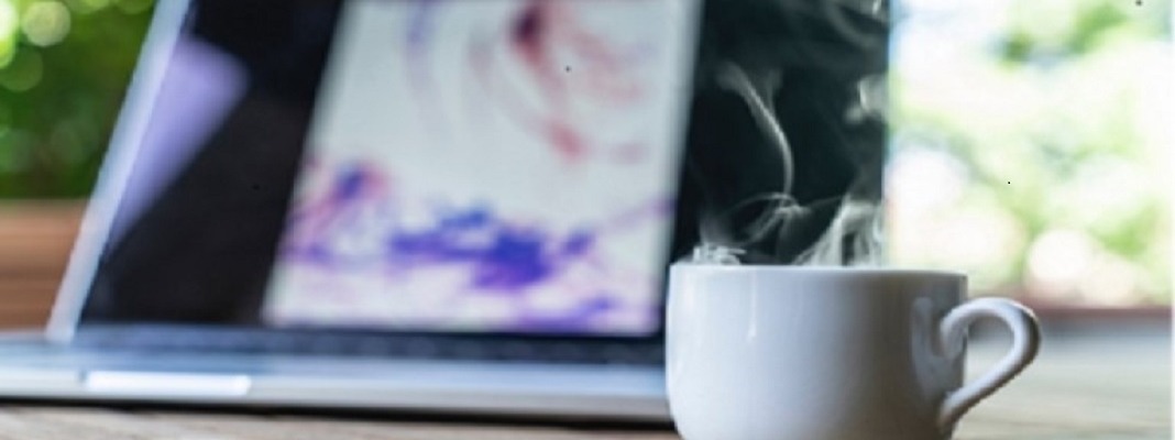 coffee cup in front of laptop