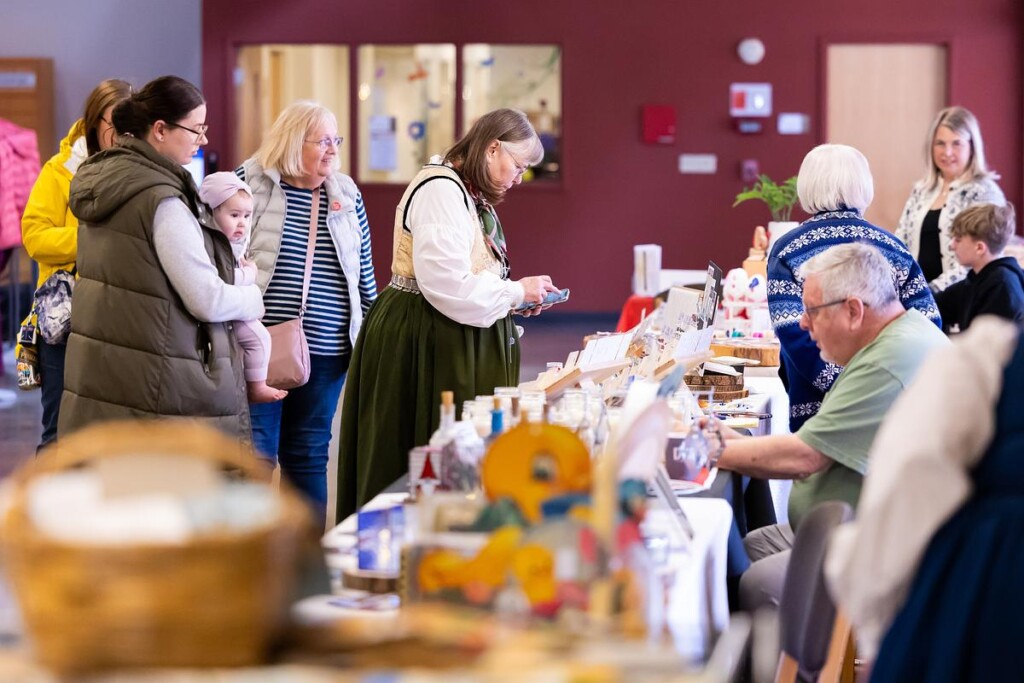 20250315_SB_Norwegian-Heritage-Fest_012-medium Long table at Norwegian Heritage festival with people perusing goods
