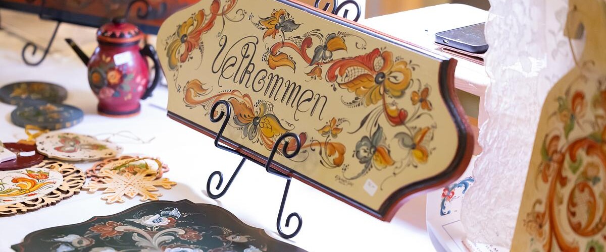 Hand-painted sign done in rosemaling style saying 