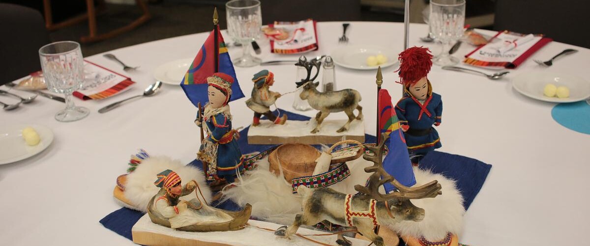 Table set with Sami carvings, slippers, and weaving