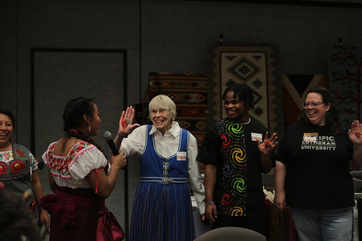 Group of people demonstrating traditional pigment making on their hands